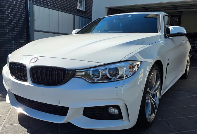 White BMW car parked in front of a building