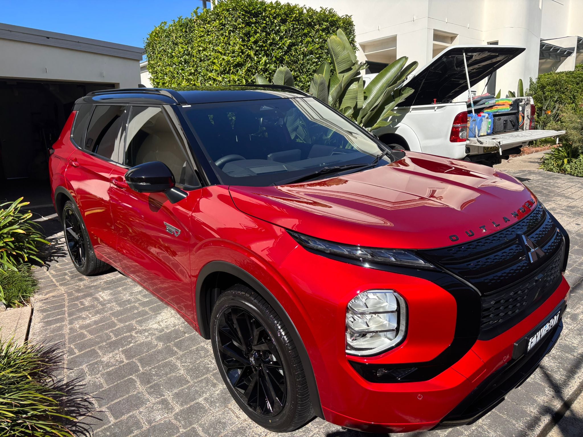 Red SUV parked on a driveway with a white house in the background