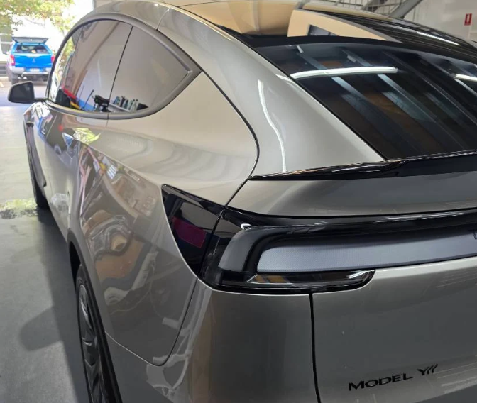 Side view of a Tesla Model Y car in a GenTek showroom.
