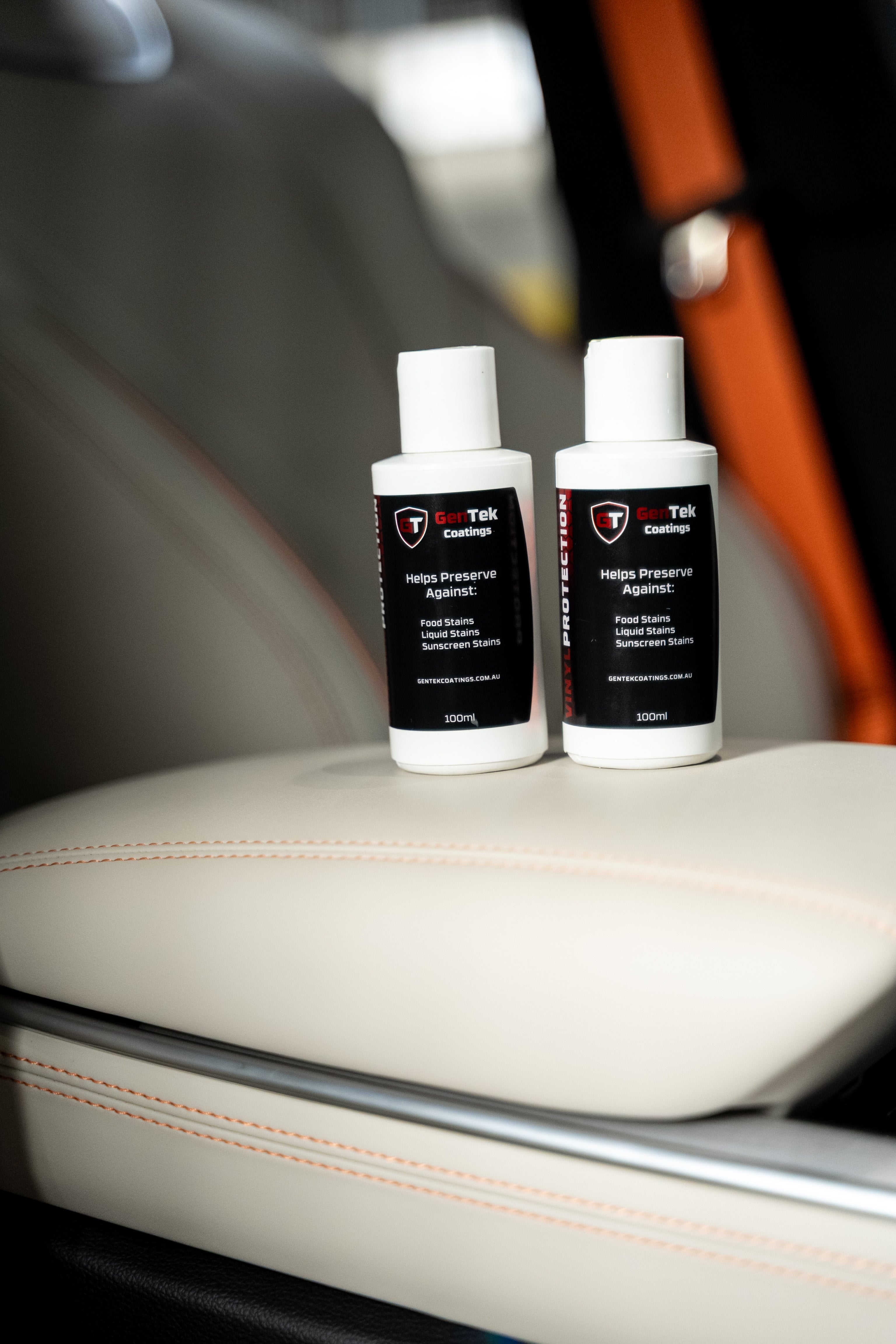 GenTek leather and vinyl protection products displayed on a light-coloured car seat.