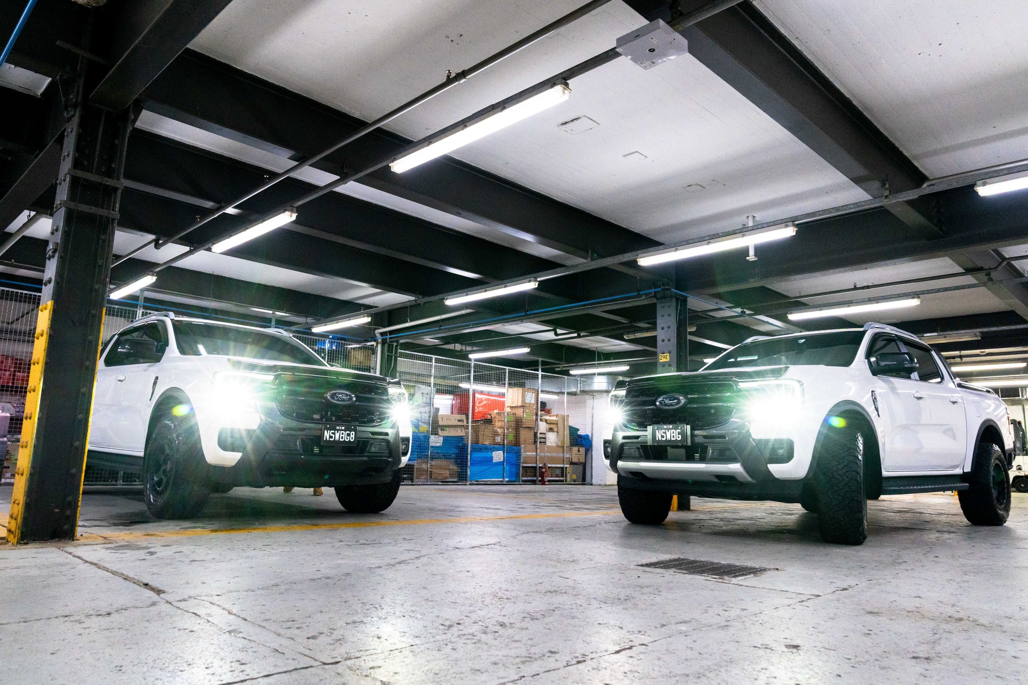 Two white Ford utes displayed inside the GenTek workshop after professional vehicle protection services.