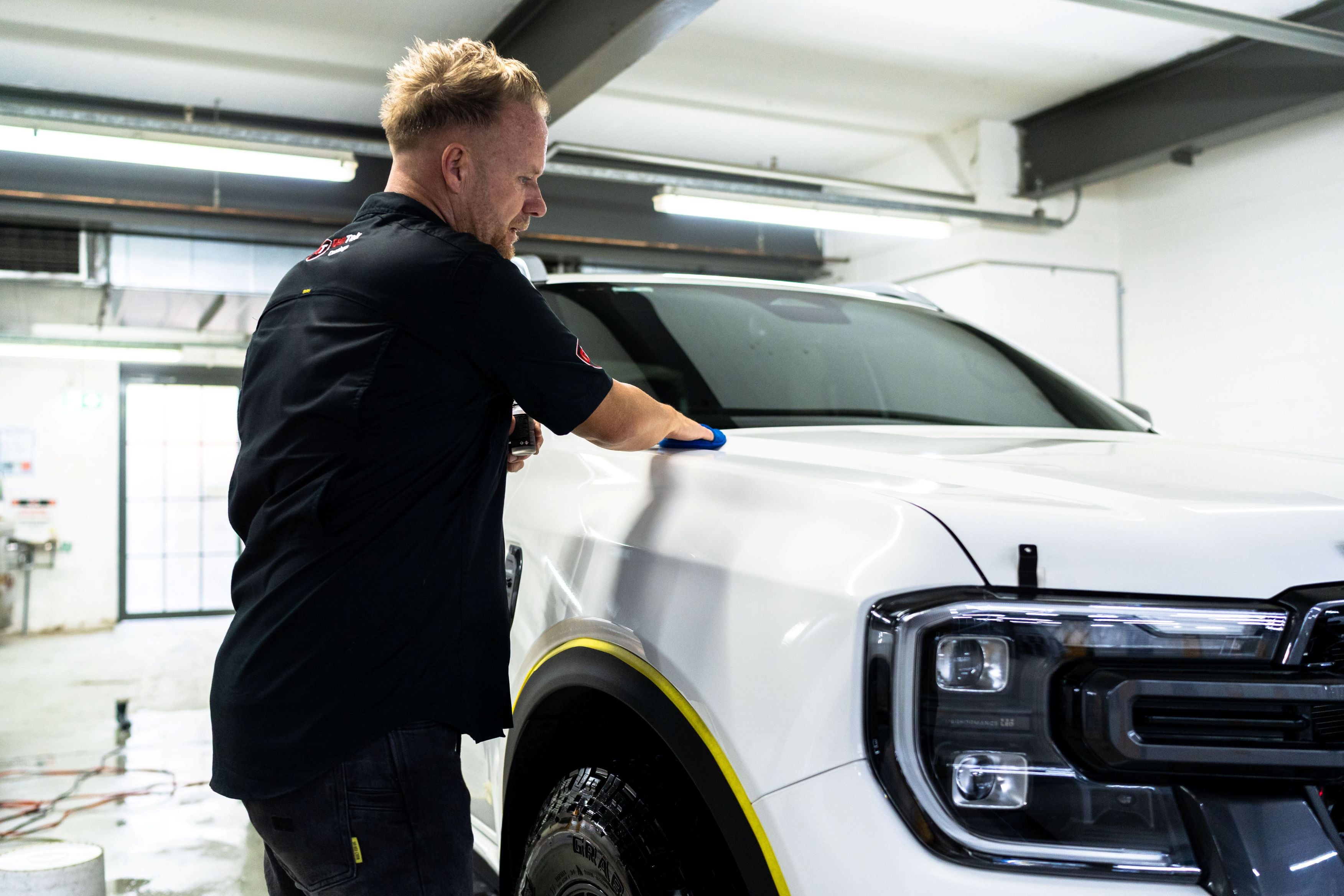 White Ford ute with professionally tinted windows being inspected by a GenTek technician.