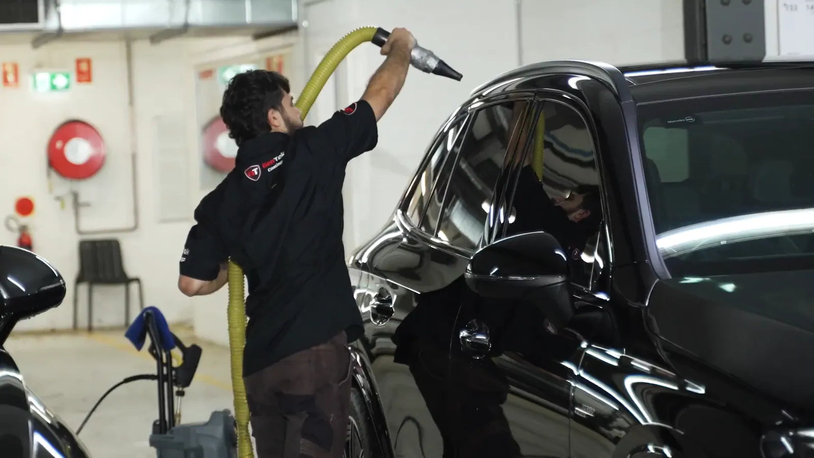 Rinsing a black car in GenTek's bay